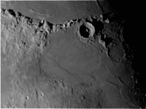 Lunar surface showing craters and uneven terrain in grayscale.